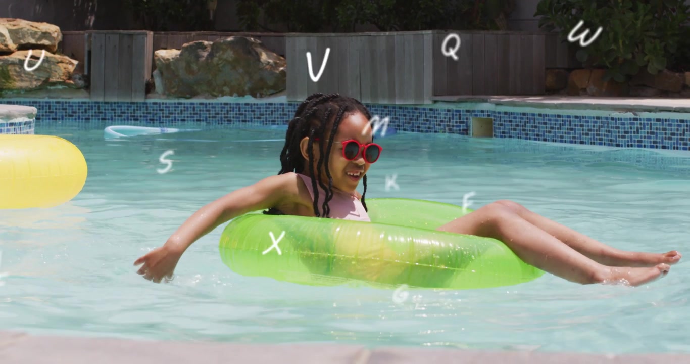 Ragazza che pagaia e scalcia, avviando un tubo verde che galleggia in una piscina da giardino per giocare, con occhiali da sole rossi