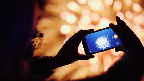 una mujer dispara fuegos artificiales en un teléfono inteligente, las luces se reflejan maravillosamente en sus gafas 4k 10 b