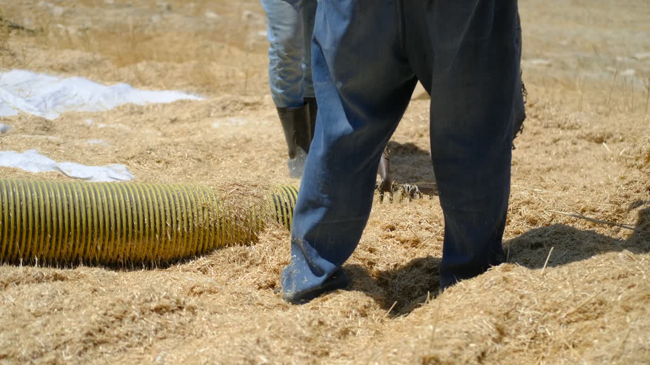 Agricoltore con irroratrice per fieno