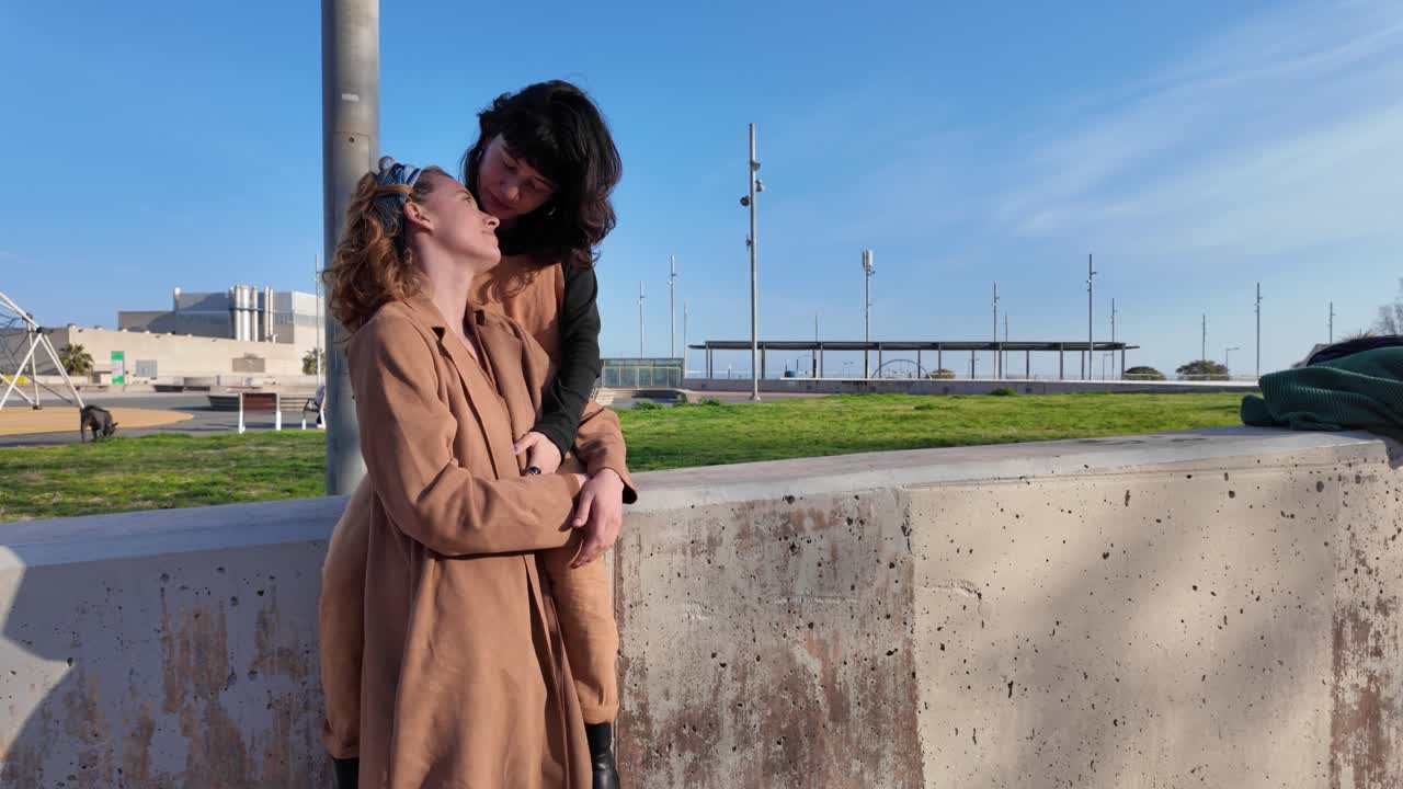 Two women affectionately holding hands in a park