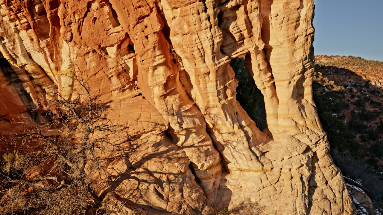 Breathtaking aerial clip of a natural rock arch catching the first rays of dawn near Kanab, Utah.