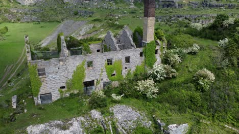 abandonado cubierto de hiedra cubierto desolado campo histórico galés costero fábrica de ladrillos molino vista aérea descendiendo cerrar