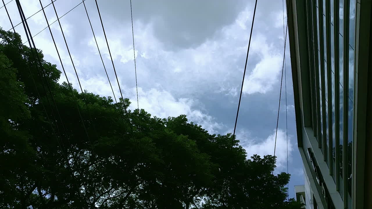 Formation of dark clouds in the sky with trees and buildings in background