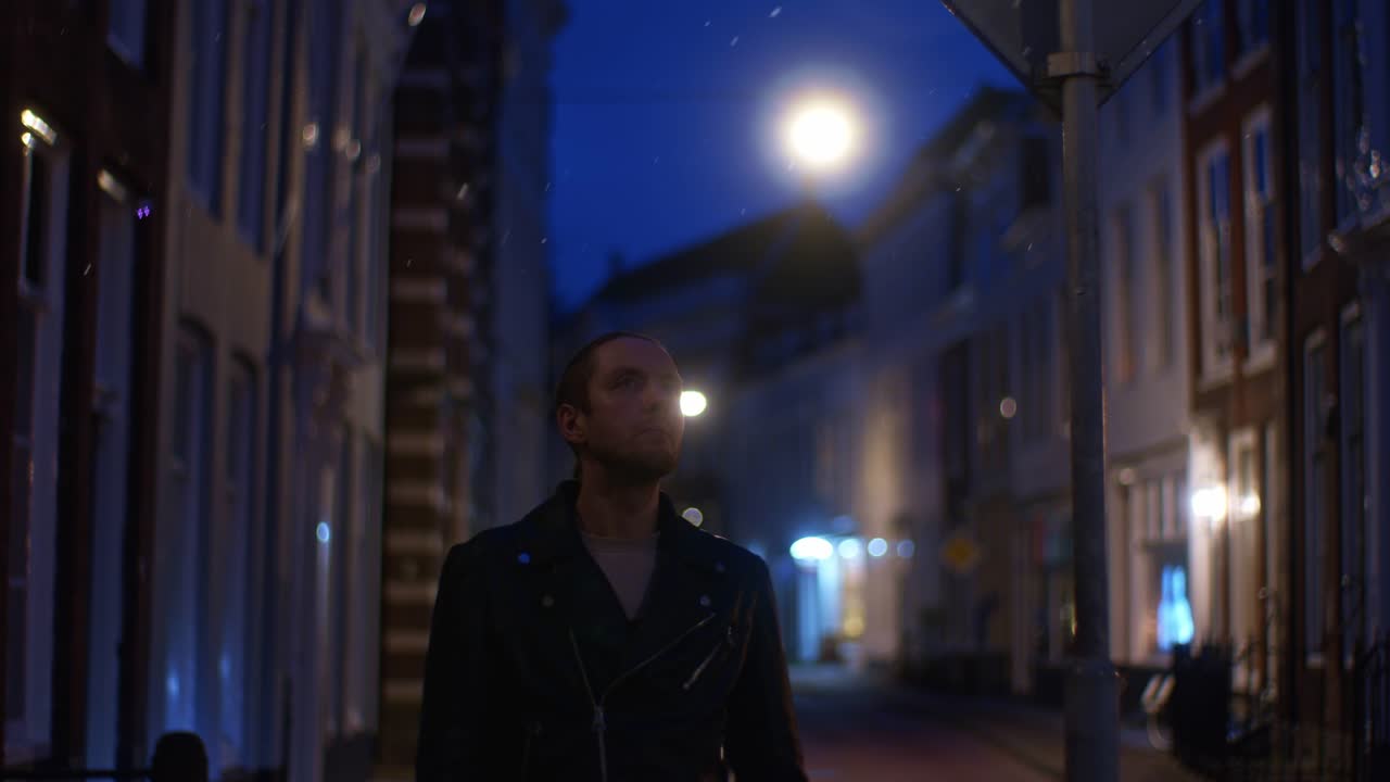 백인 남성 백인 모델은 유럽에서 야외 거리에서 는 동안 밤에 눈과 눈이 내리는 겨울 시즌에 무대화 된 역할을합니다.