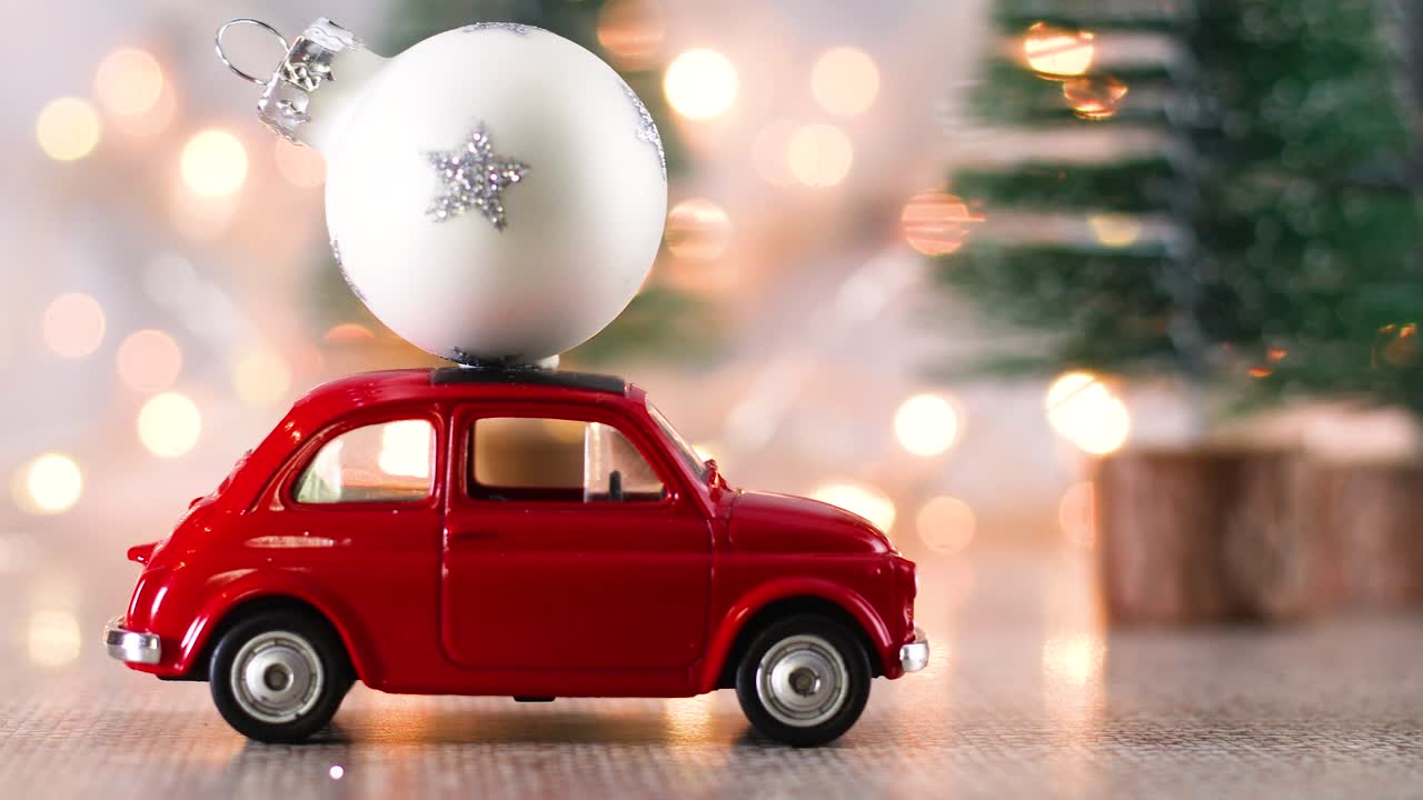 mini coche rojo con ornamento de navidad blanco en el techo