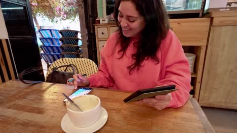 young woman using smartphone and tablet in cafe