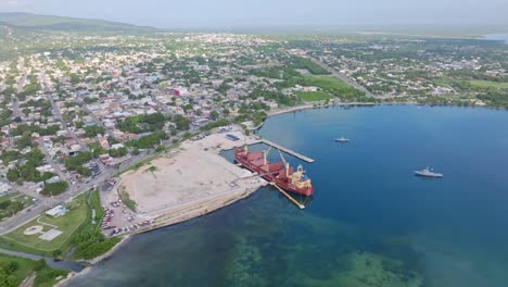 aerial view of barahona pier during building phase and docking industrial ship on dominican republic