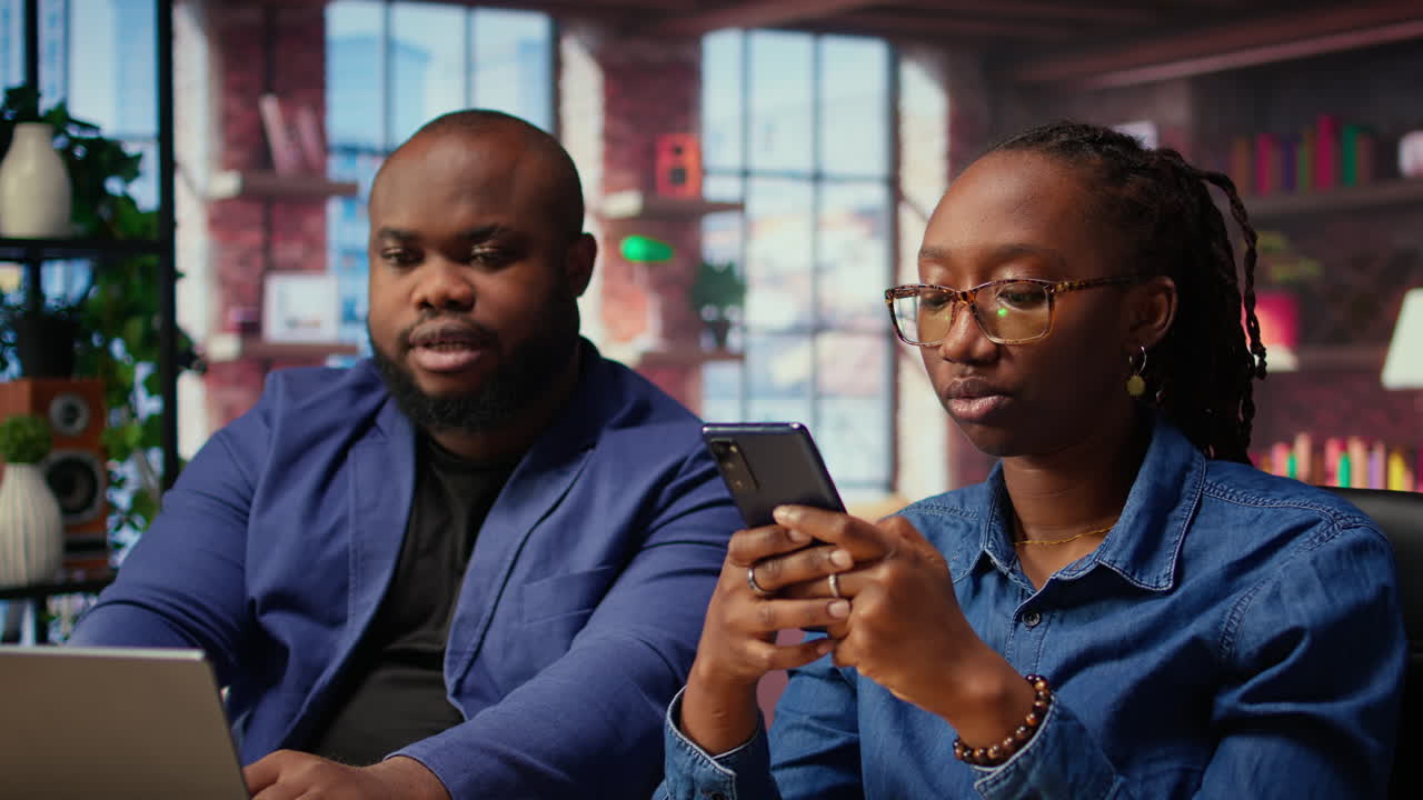 Black couple sitting together at home office and managing their affairs