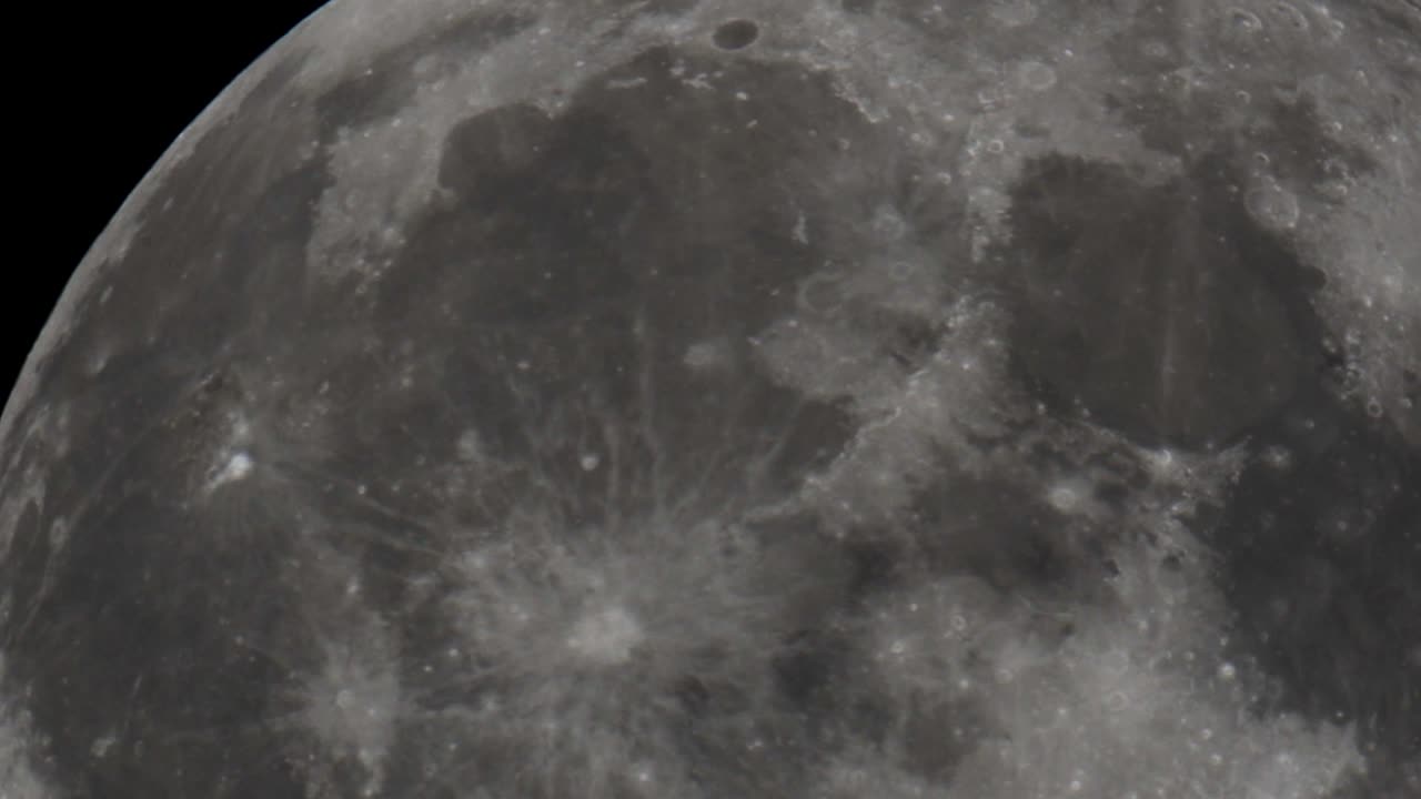 망원경으로 찍은 우주의 밤하늘을 가로지르는 거대한 보름달의 초망원 영상