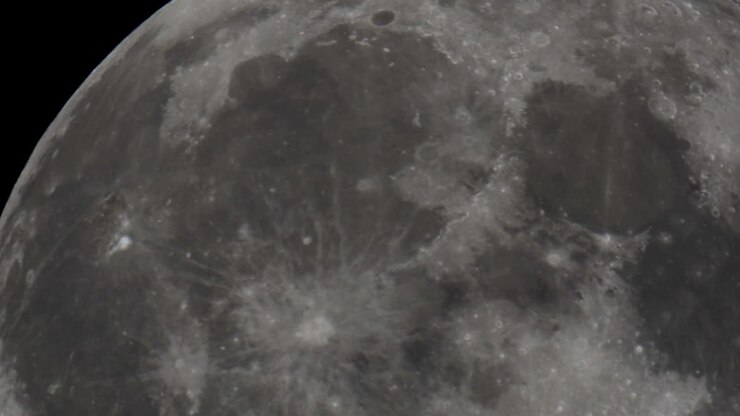 Um vídeo super telefoto da Lua Cheia gigante passando pelo céu noturno no espaço, filmado com um telescópio