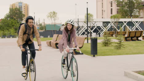 amerikanischer mann und frau, die fahrrad fahren und miteinander reden, während sie zur arbeit gehen 3