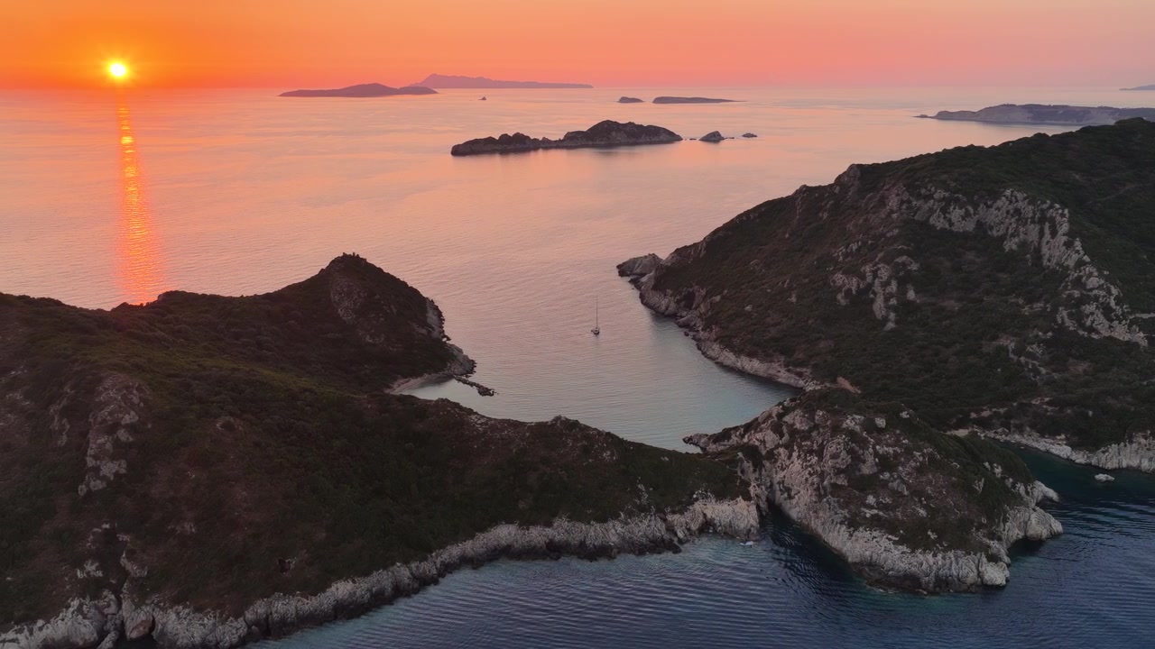 Paesaggio aereo della spiaggia doppia di Porto Timoni e della costa della Baia Gemella al tramonto, Corfù, Grecia.