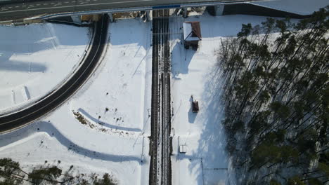 bird's eye view of roads and railways in countryside landscape during winter in rakowice, krakow, poland - aerial drone shot