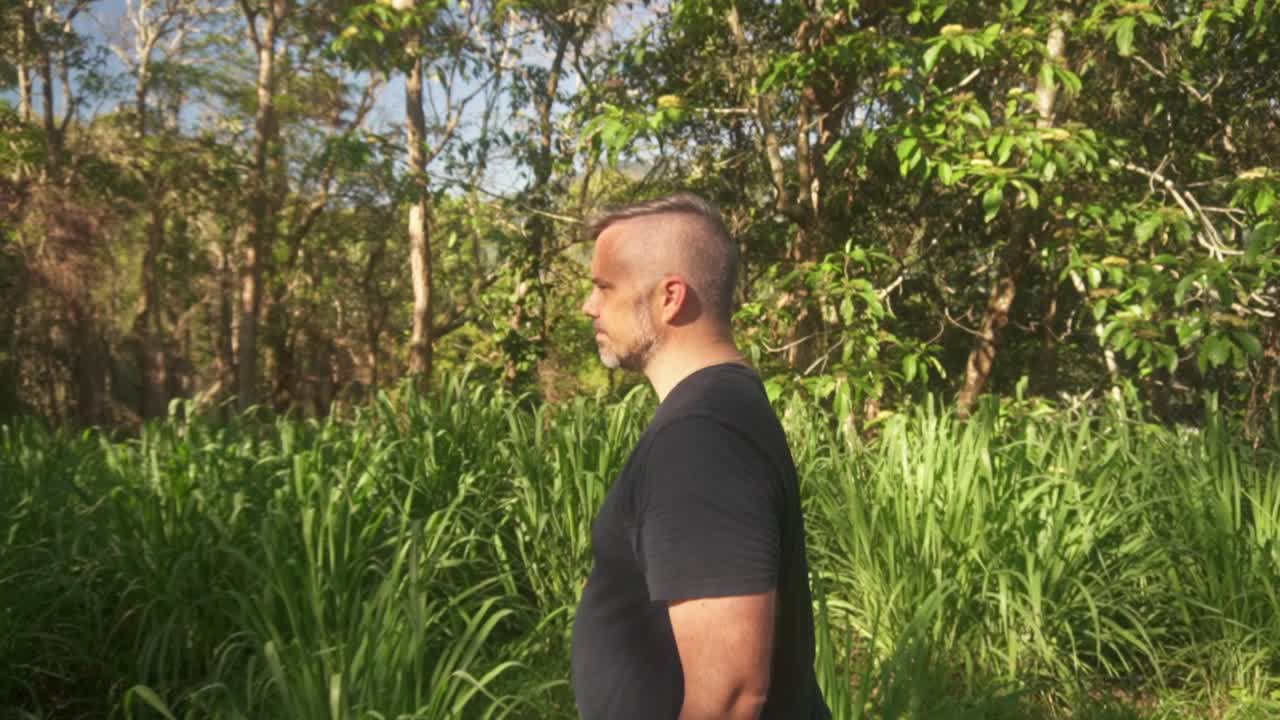 side shot of man walking along nature walk.