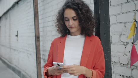mujer joven enviando mensajes de texto en el teléfono inteligente en la ciudad