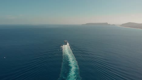 aerial high view passenger vessel moving away, island as background