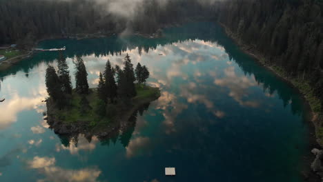 Perfect-reflections-Of-Blue-Sky-And-Clouds-At-Lake-Caumasee-Surrounding-By-The-Green-Forest-During-Summer-In-Grisons,-Switzerland