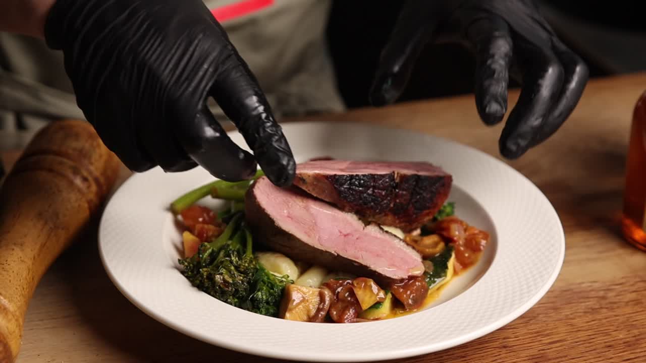 Chef Plating Gourmet Duck Breast with Roasted Vegetables