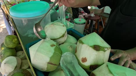 street vendor skillfully chopping coconuts for juice