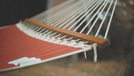 Rack-Focus-Hammock-Swaying-In-Breeze-During-Autumn-with-Colored-Leaves-on-Ground-4K-ProRes