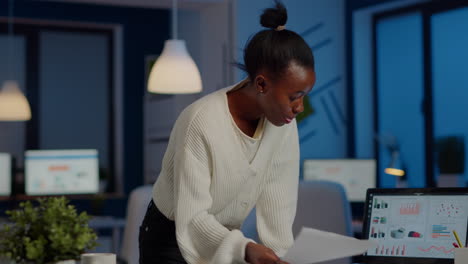 stressed african manager woman reading raports, standing at desk