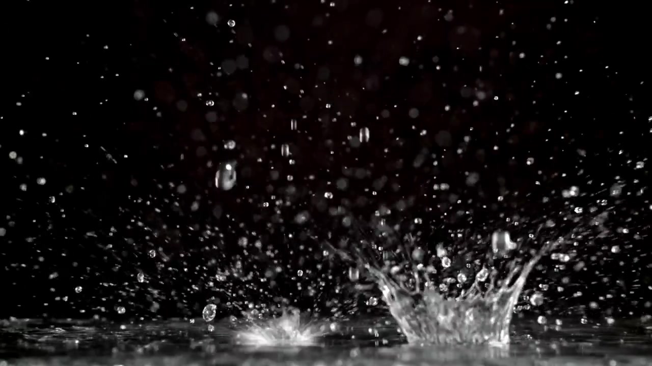 暗い表面に飛び散る水滴のスローモーション