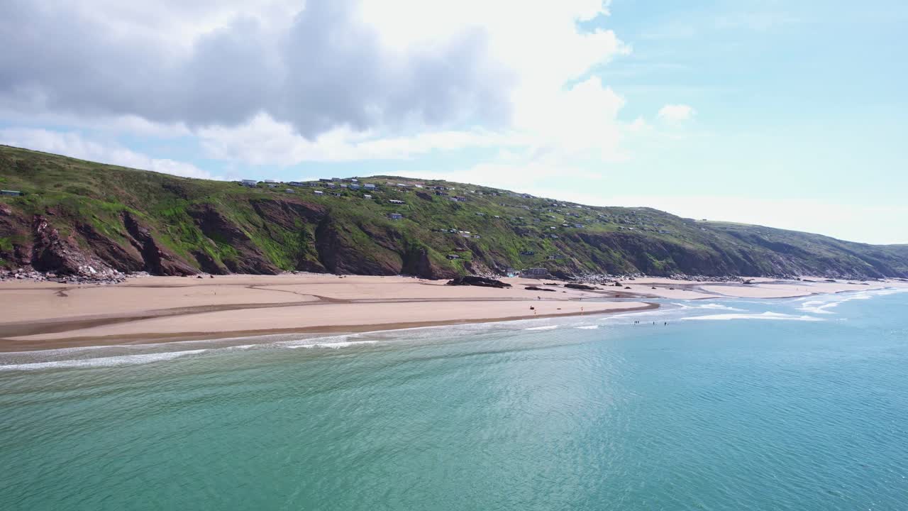 An aerial drone captures the scenic beauty of Whitsand Beach on the Cornish coastline, nestled along the cliffs of Cornwall, England, on a sunny summer's day