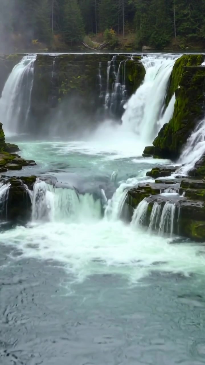 Video verticale: Fiume che scorre e spinge una cascata oltre le sporgenze rocciose in un canyon, creando nebbia d'acqua bianca.