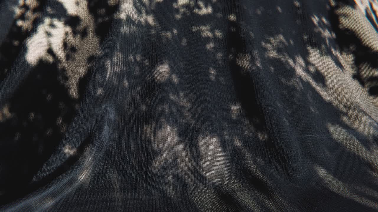 Dynamic Light and Shadow Patterns on Dark Textured Fabric