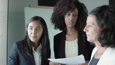 serious businesswomen standing and discussing project