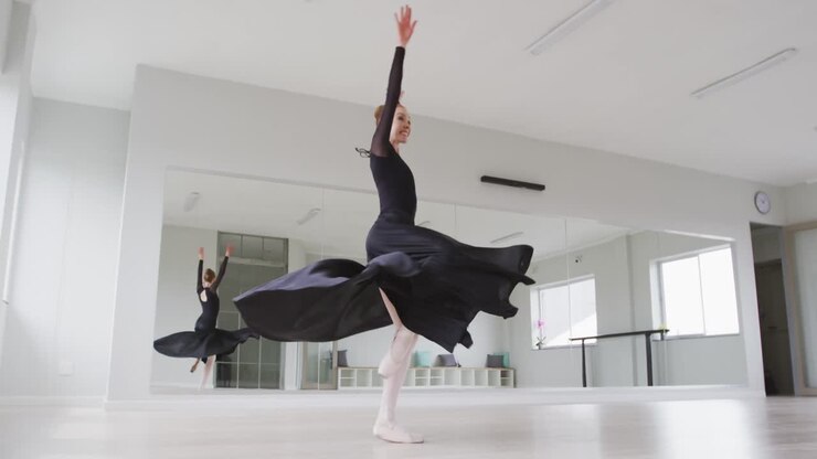 Ballerina di danza classica caucasica che si esercita nella danza classica durante una lezione di danza in uno studio luminoso