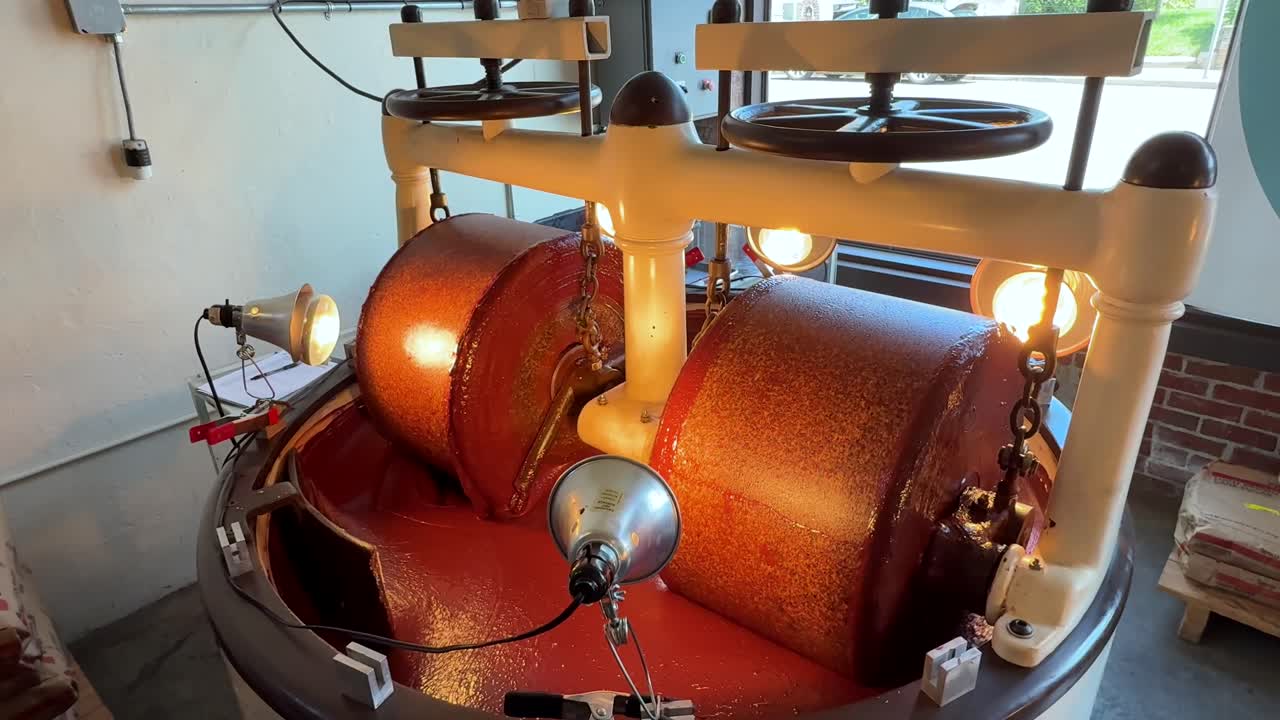 Premium Chocolatier Manufacturing Chocolate Bars, Batch Of Nibs Refined Down To Liquid On A Machine