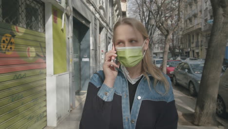 mujer con máscara hablando en móvil estilo de vida al aire libre durante el coronavirus