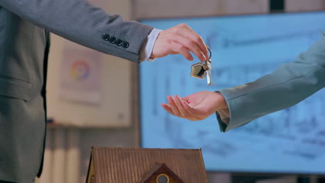 property taxes and mortgage concept. broker selling an apartment gives the keys to a business man, hands close-up. real estate investment, smart home rental