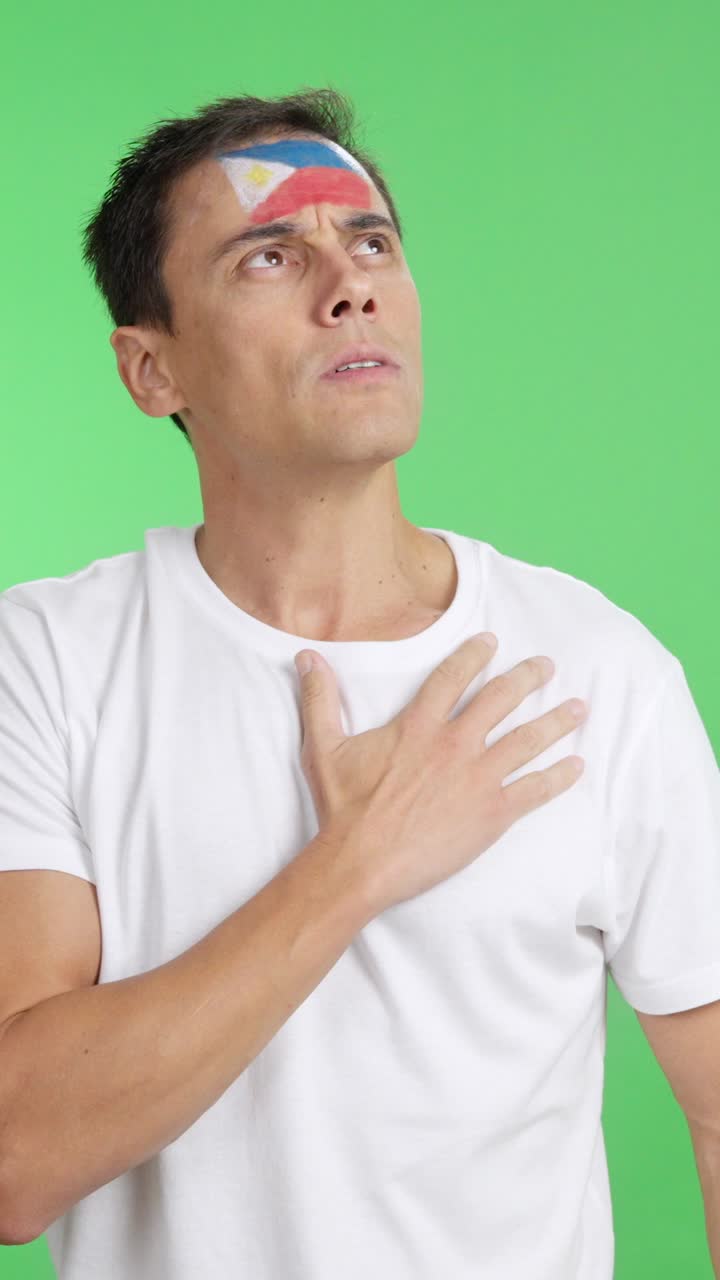 Man listening to the Philippines national anthem with solemnity