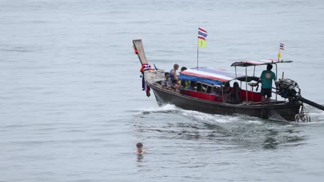 boat approaches swimmer in calm waters