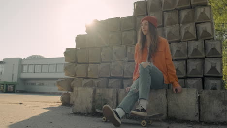 skater girl waiting for someone sitting on a cement block