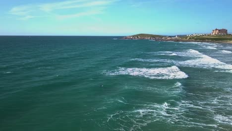 aerial side-shot of surfers waiting for a wave at fistral beach, newquay, cornwall