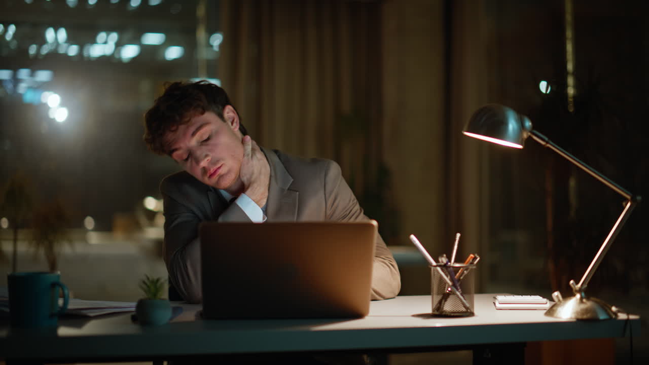 Tired entrepreneur working night office closeup. Exhausted manager rubbing neck