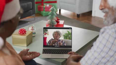 feliz pareja de ancianos afroamericanos en videollamada con una amiga mayor en navidad