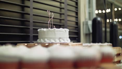 wedding dessert table, rack focus camera slide from cupcakes to monogram cake topper