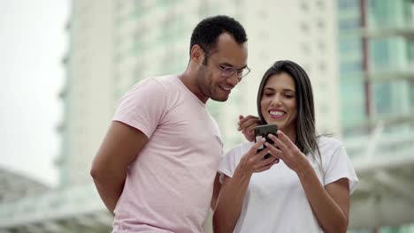 Lächelnde-Freunde,-Die-Auf-Ihr-Smartphone-Schauen-Und-Lachen