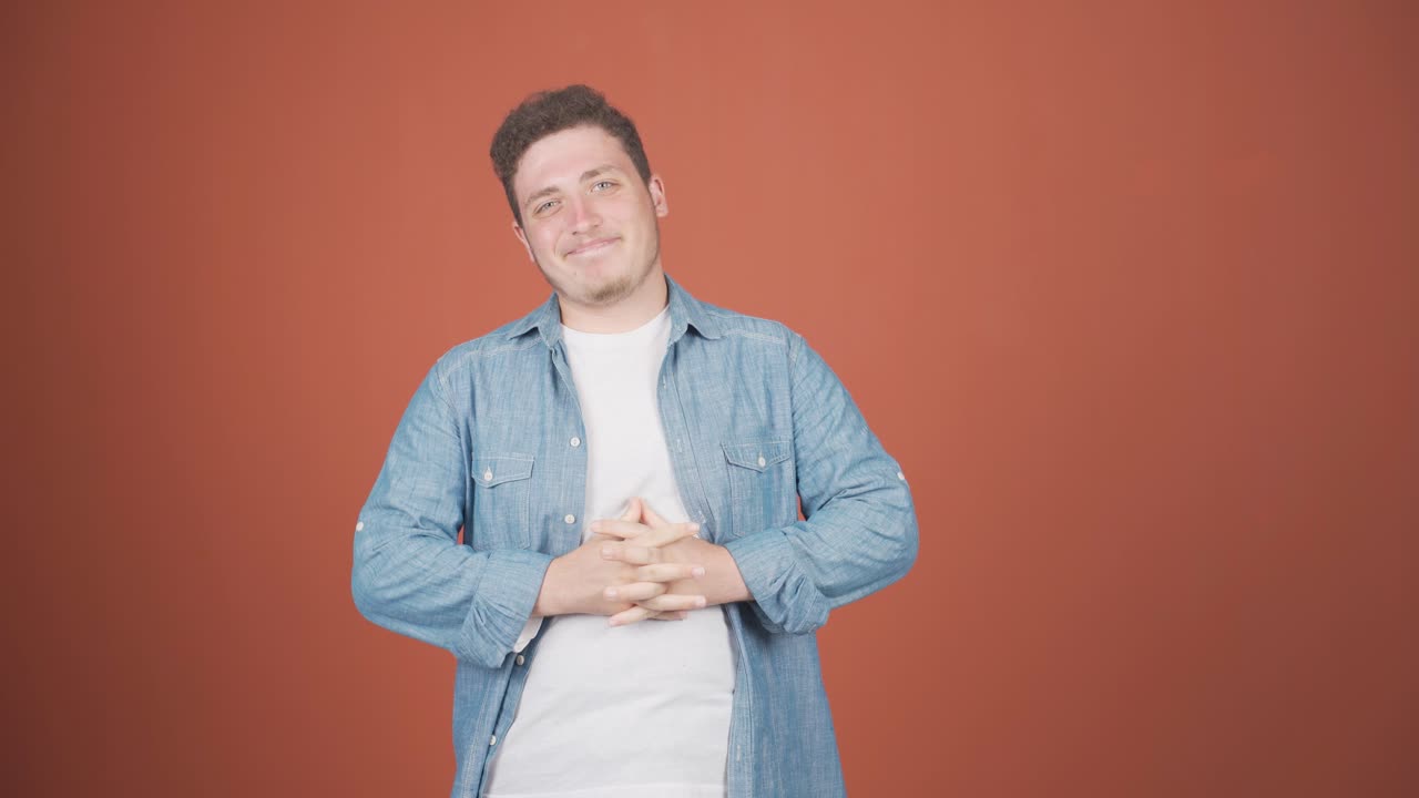 카메라를 위해 귀여운 몸짓을 하는 남자.