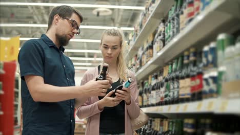 couple shopping for beer in grocery store