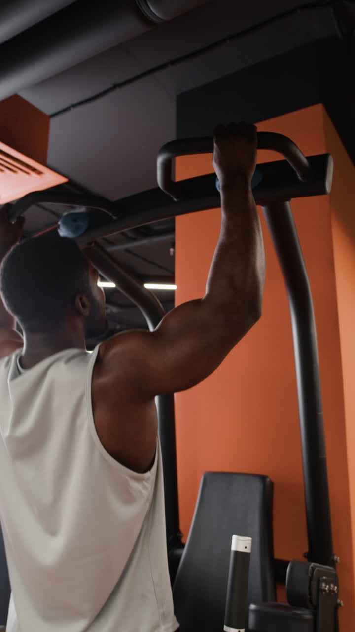 hombre realizando pull-ups en un gimnasio