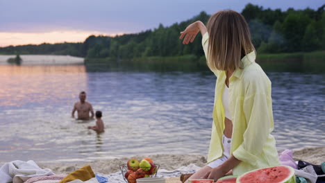 kobieta cięła arbuz na plaży.