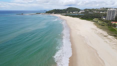 white sand of palm beach seashore with a view of currumbin point in australian state of queensland