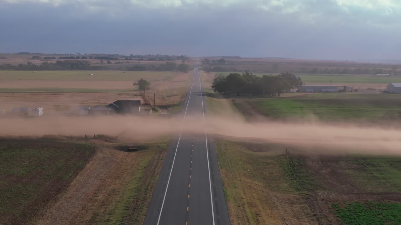 Dust storm crossing highway in rural Oklahoma, tranquil yet dramatic