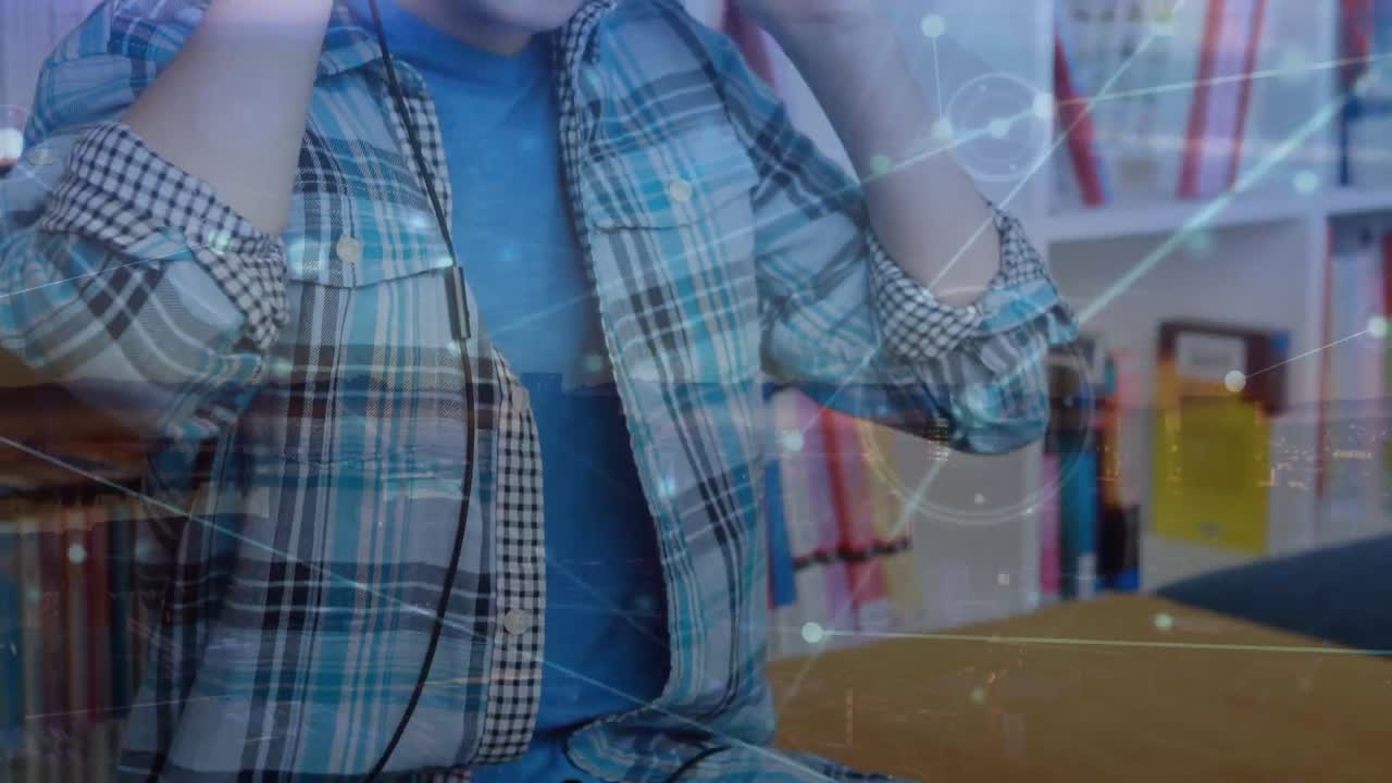 animación de procesamiento de datos e íconos de medios sobre escolar caucásico escuchando música