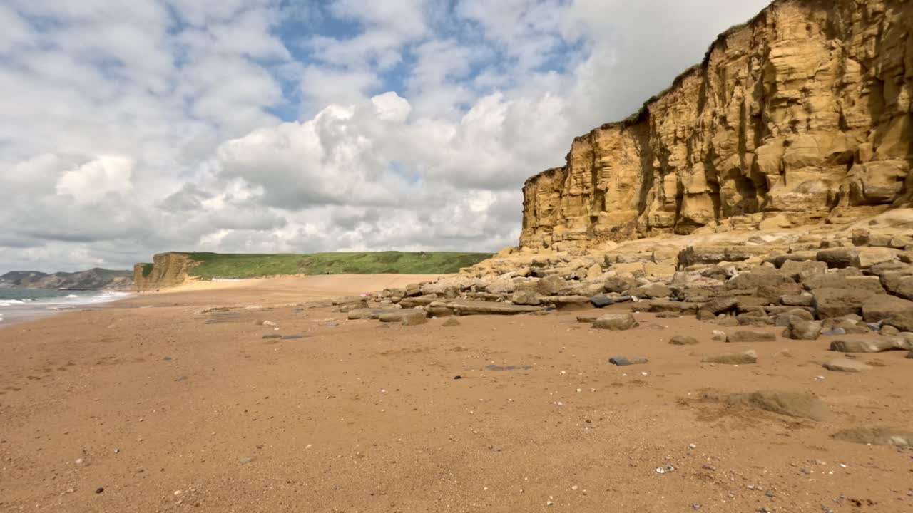 Wide footage of a dramatic cliff on the south coast of England, known as the Jurassic Coast. Captured on a sunny spring day the footage moves to the left revealing the sea on the left